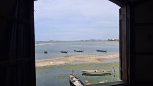 - une fenêtre donnant sur une plage avec des bateaux dans l'eau dans l'établissement Kitinet semi mobiliada ótima localização, à São Pedro da Aldeia
