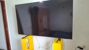un téléviseur à écran plat accroché au mur dans l'établissement Kitinet semi mobiliada ótima localização, à São Pedro da Aldeia