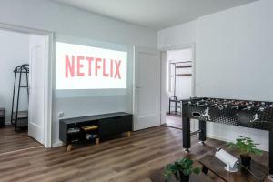 a living room with a netflix sign on the wall at Direkt am Königsplatz l Für 8 Personen l Beamer l Foosball in Augsburg