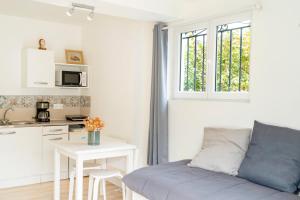a living room with a couch and a table and a kitchen at Chambre indépendante, tout à pied in Ciboure