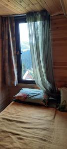 a bed in a room with a window at Bakhmaro Lodge in Bakhmaro