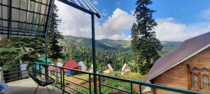 a balcony with a view of the mountains at Bakhmaro Lodge in Chʼkhakoura