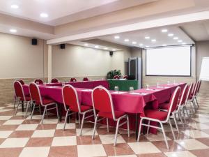 Una sala de conferencias con una mesa larga y sillas rojas. en ibis Styles Roma Vintage, en Roma