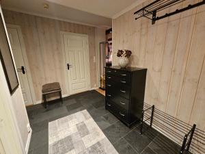 Una habitación con una cómoda negra con un jarrón. en Leilighet Gaustablikk, en Rjukan 20 fotos más