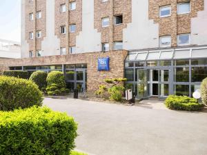 a brick building with a blue sign in front of it at Ibis Budget Fresnes Orly in Fresnes