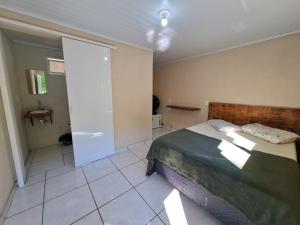 a bedroom with a large bed and a bathroom at Cabanas V13, segundo maior viaduto do mundo! Sem ar in Vespasiano Corrêa