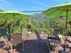 a group of chairs and umbrellas on a deck at Cabanas V13, segundo maior viaduto do mundo! Sem ar in Vespasiano Corrêa +17 photos
