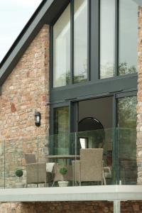 an extension to a house with black windows and chairs at Hill View House - Cookswood in Holcombe