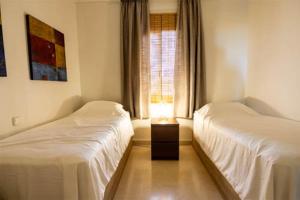a bedroom with two beds and a lamp on a table at appartement gelegen aan de golfbaan op La Quinta Benahavis Marbella in Benahavís