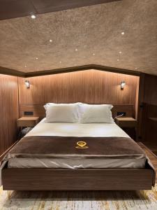 una camera da letto con un letto grande con testiera in legno di The HH Point a Tirana