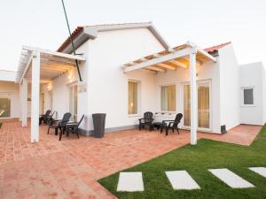 a patio with black chairs and a white house at Tavira Monte in Tavira