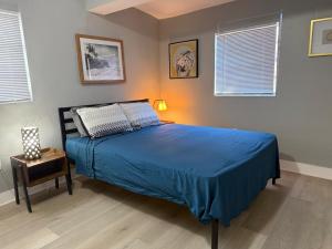 a bedroom with a bed with a blue comforter at Modern cozy home with private patio - Sleeps 6 in Miami