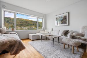 un salon blanc avec un canapé et une table dans l'établissement Costal Penthouse by Paramount, à Tromsø