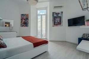 a white bedroom with a bed and a television at Casa Mia Nazionale in Rome