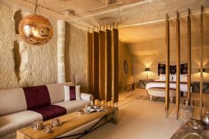 una sala de estar con un sofá y una cama en Hezen Cave Hotel, en Ortahisar