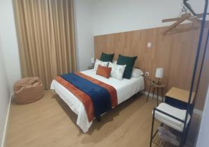 a bedroom with a large bed and a chair at Cottage em Valença in Valença +6 photos