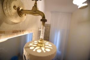 マテーラにあるLo splendore dei Sassiの真鍮製の洗面台付きのバスルームライト