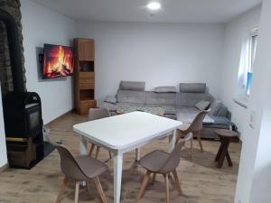 a living room with a table and chairs and a couch at Ferienhaus hERZgebirge in Bockau