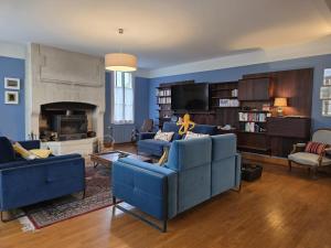 a living room with two blue couches and a fireplace at Wisdom - Mansion, with majestic charm in Braine