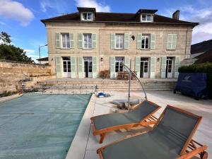 a house with a pool and two chairs in front of it at Wisdom - Mansion, with majestic charm in Braine