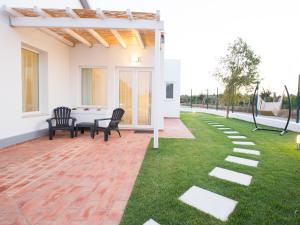 a patio with chairs and a table on a lawn at Tavira Monte in Tavira