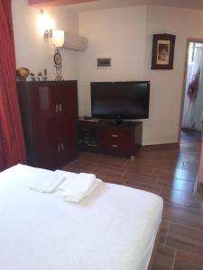 a bedroom with a bed and a flat screen tv at Apartments Mara Bela in Karlobag