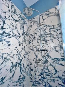 a shower in a bathroom with a marble wall at Maison moderne avec jardin au cœur du vignoble in Westhalten