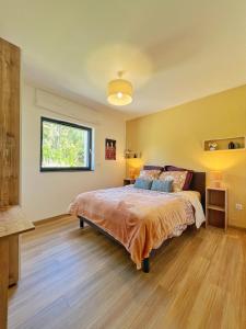 a bedroom with a large bed and a window at Maison moderne avec jardin au cœur du vignoble in Westhalten