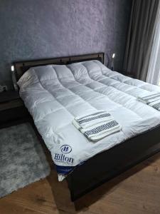 - un lit avec une couette blanche au-dessus dans l'établissement Luxury apartment in building K55 with free garage, à Varna