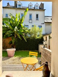 Un patio con una mesa amarilla y una silla amarilla. en Le Duplex de Jean, Centre de Rennes, en Rennes