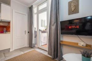 Una sala de estar con televisión y una ventana. en Canteras Seaviews - Balcony & Beach, en Guanarteme