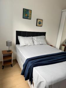 una camera da letto con un letto con una coperta blu sopra di Casa completa em Caraguatatuba - Rio do Ouro a Caraguatatuba