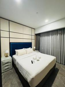 a bedroom with a large white bed with a blue headboard at Platinum Suites Klcc By Divina in Kuala Lumpur