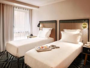 a hotel room with two beds and a window at Mama Shelter Paris West in Paris +111 photos