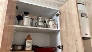 a kitchen pantry with pots and pans on a shelf at Cozy Apartment Near Rabat & Beach in Temara