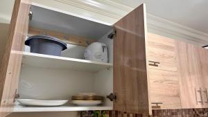 a kitchen with a cupboard with some dishes in it at Cozy Apartment Near Rabat & Beach in Temara +13 photos