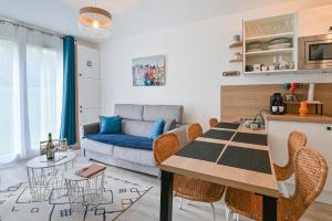 a kitchen and living room with a table and chairs at Le Casa Délia in Équemauville