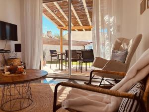 a living room with a couch and chairs and a table at Le Cottage de Felix in Canet d'Aude