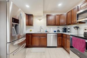 Una cocina con gabinetes de madera y electrodomésticos de acero inoxidable. en Gibbs Getaway, en Leicester