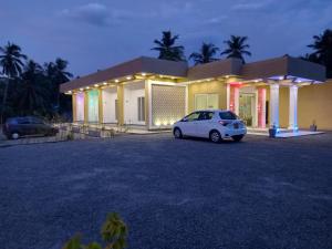 a white car parked in front of a house at Onera Hotel & restaurant in Mahiyangana