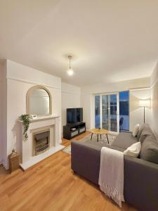 a living room with a couch and a fireplace at Stockport Stays in Stockport
