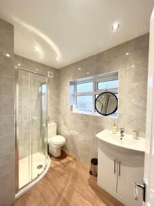a bathroom with a shower toilet and a sink at Stockport Stays in Stockport