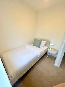 a small bedroom with a bed and a side table at Stockport Stays in Stockport +3 photos