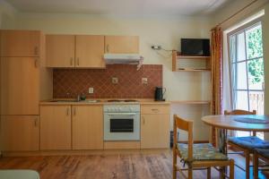 a kitchen with wooden cabinets and a table with chairs at Apartmány Lékařský dům in Pec pod Sněžkou +19 photos