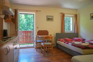 a bedroom with a bed and a table and a kitchen at Apartmány Lékařský dům in Pec pod Sněžkou