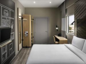 a hotel room with a bed and a desk at Ibis Jeddah Malik Road in Jeddah +169 photos