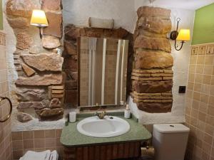 bagno con lavandino e parete in pietra di LA COVETA RURaL a Vilafamés Altre 47 foto