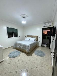 1 dormitorio con 1 cama y 2 alfombras en el suelo en Réservez dès maintenant Calme confort et proximité, en Oulad Mbark