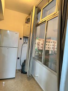 cocina con ventana y nevera en una habitación en Réservez dès maintenant Calme confort et proximité, en Oulad Mbark