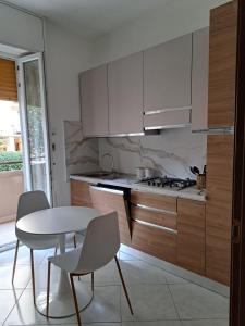 a kitchen with a table and chairs and a stove at Appartamento MonteNero in Novara